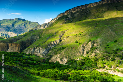 Picturesque mountain landscape with green slope and mountain river at the base of the mountain in Dagestan, Caucasus