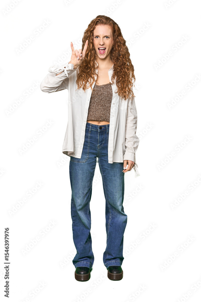 Full-body redhead portrait showing a horns gesture as a revolution concept. Full-body redhead portrait showing a horns gesture as a revolution concept.