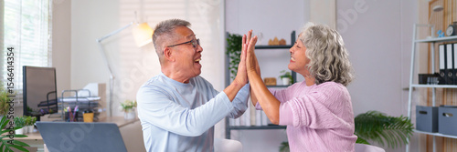 Cheerful Senior Asian Couple Giving High Five at Home Office Celebrating Success Together Happy Old Husband and Wife Enjoying Retirement Life