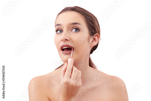 Young woman applying lipstick on her lips with a lip brush applicator as part of her makeup routine. Smooth, flawless complexion. Beauty concept, isolated on white background, looking into camera