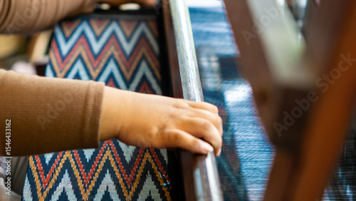 Making tenun ikat Bandar, Indonesia. An Indonesian woman weaving traditional fabric. Traditional weaving cotton in Indonesia.
