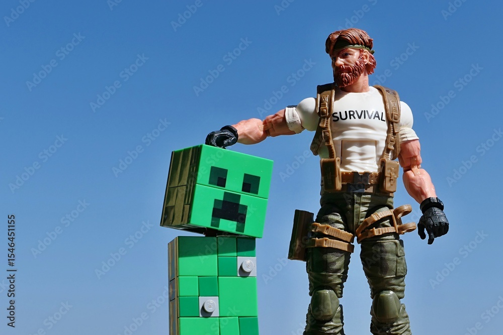 Obraz premium GI JOE figure of survival instructor Outback, series Classified 2023, stroking head of tamed LEGO Minecraft green explosive mob Creeper on bright daylight sunshine, blue skies in background.