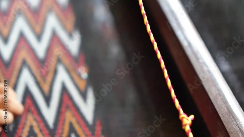 Making tenun ikat Bandar, Indonesia. An Indonesian woman weaving traditional fabric. Traditional weaving cotton in Indonesia.