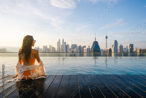 A woman in a bikini enjoys the rooftop pool and skyscrapers in a modern city