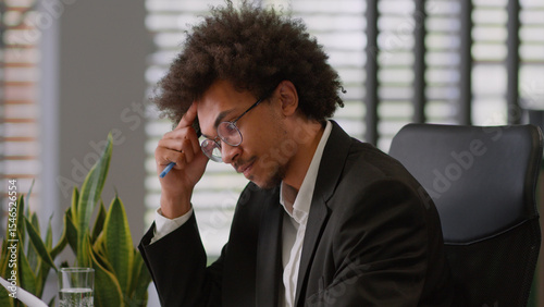 Pensive thinking think thought African American man business male guy businessman employer entrepreneur holding paper document result research analyze company budget finance working laptop in office