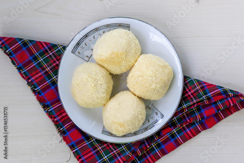 Tasty Kachagolla sweets, a popular Bengali dessert, on ceramic plate. Known for soft, spongy texture and subtle sweetness. Top view.
