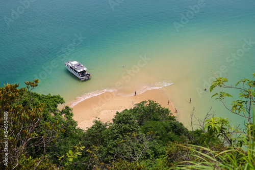 Picturesque view to sandy beach and tourist motor boat on tropical island in Andaman sea. Background for travel on paradise nature
