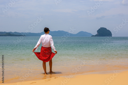 Woman standing on sandy beach of tropical island in Andaman sea. Concept of travel on paradise nature