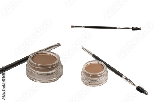 A brow pomade in blonde shade with brush isolated on a white background.