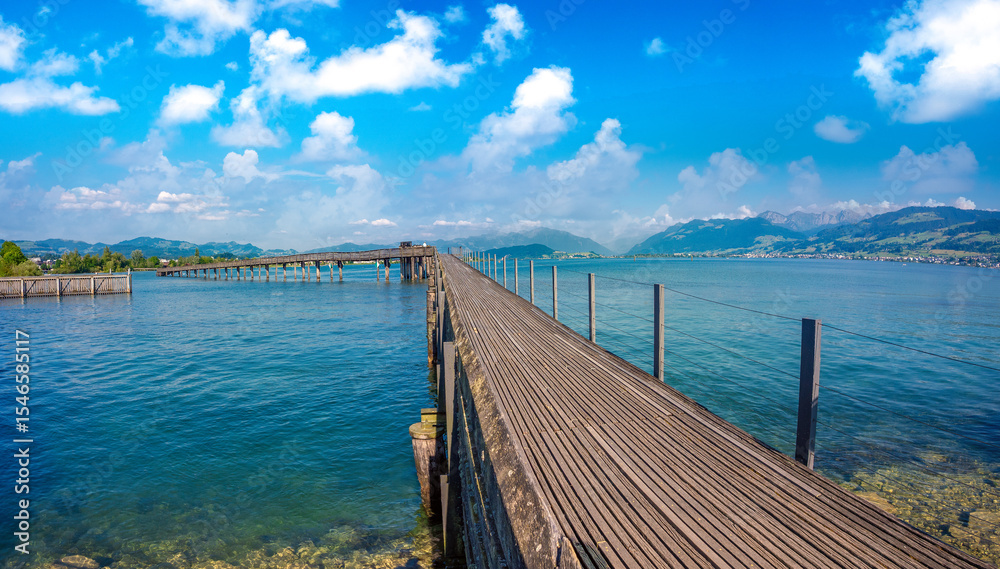 Obraz premium The longest wooden bridge in Switzerland, Holzbrücke Rapperswil-Hurden, spanning the narrowest and shallowest part of Lake Zurich.