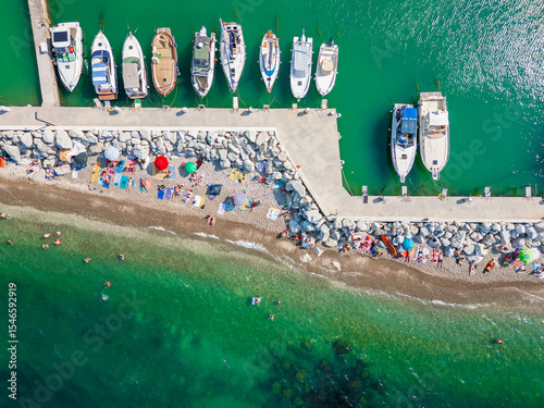 Italy, June 22, 2025: aerial view from the drone of the Vallugola Bay with its tourist port immersed in the San Bartolo park near Pesaro and the Romagna coast