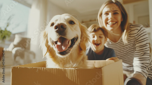 Excited parents and their son playing with their dog while unpacking after moving into a modern family house moving in day, family togetherness, cardboard boxes, dog in box, kid an