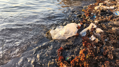 Foto Plastic waste and debris on a polluted shoreline