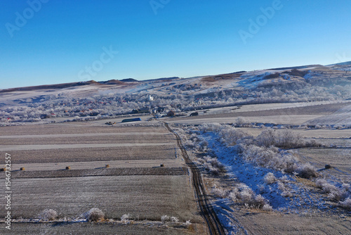 Aerial view of a misty countryside village, in early morning lights