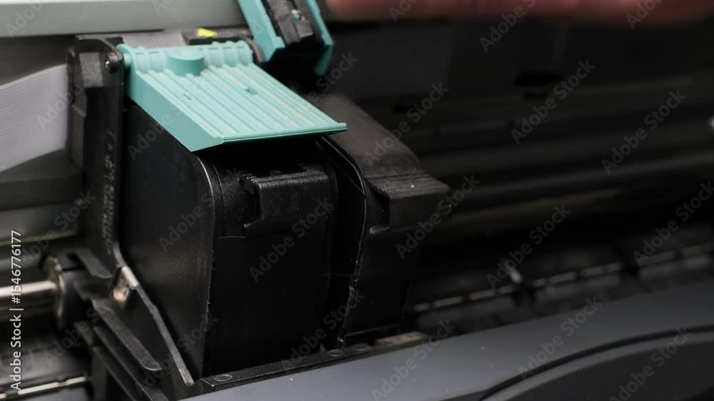 Close-up of hand carefully replacing inkjet printer cartridges inside a home office printer setup Close-up of hand carefully replacing inkjet printer cartridges inside a home office printer setup