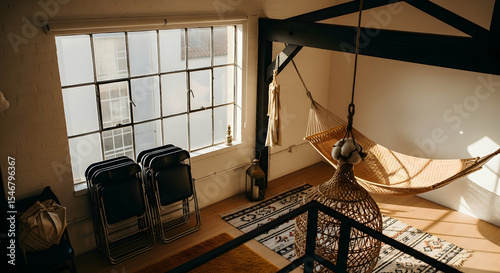 Bohemian Loft Interior with Hammock and Natural Light Through Large Window