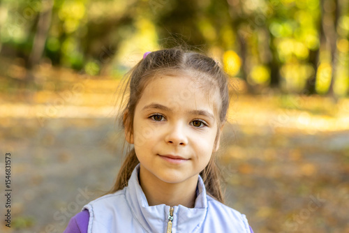 Portrait of a happy child outdoors in a sunlit natural park setting