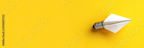 Origami lightbulb on bright yellow background