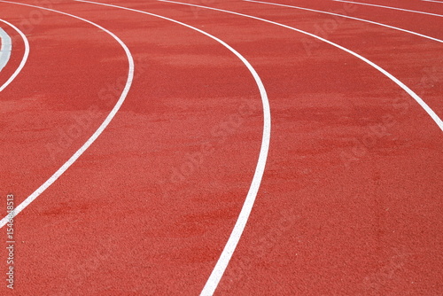 Red artificial running track with white round dividing lines, treadmill rubber texture, sports, athletics