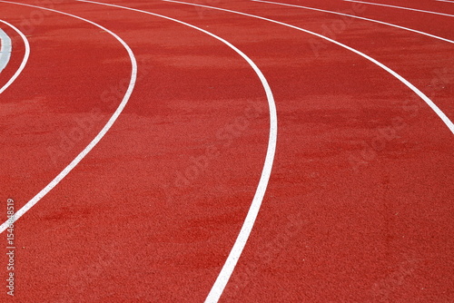 Red artificial running track with white round dividing lines, treadmill rubber texture, sports, athletics