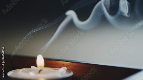 Soft smoke rising from incense sticks and candles in a calm spiritual setting.  
