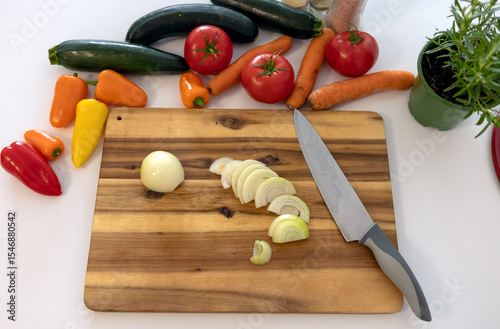 top view cutting board with knife and fresh vegetables: carrots, eggplant, tomatoes, onions, zucchini. cooking vegetable stew. benefits of fresh vegetable dishes, vegetarianism