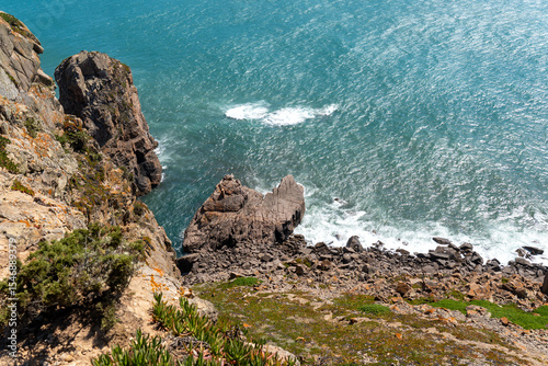 Steep rocky cliffs meet the vibrant turquoise Atlantic Ocean in the Lisbon area, perfect for nature, travel, and adventure themes. Ideal for scenic landscape inspiration.