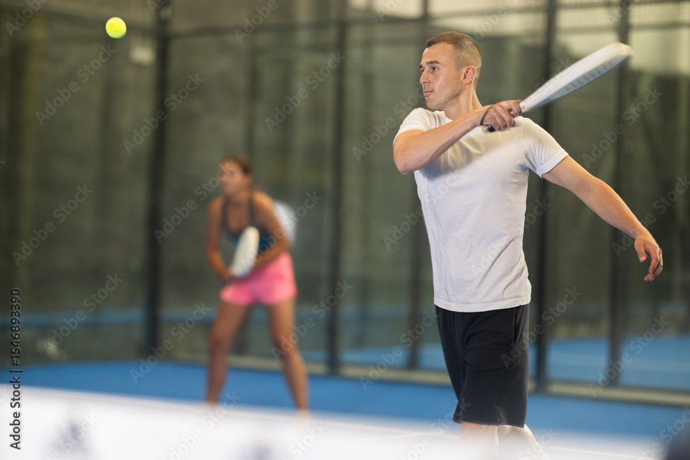 Fototapeta premium Young woman and young guy in doubles play tennis on tennis court