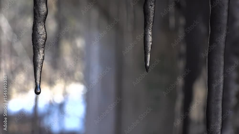A detailed view of pointy melting icicles hanging in a tunnel, emphasizing cold and serene beauty.