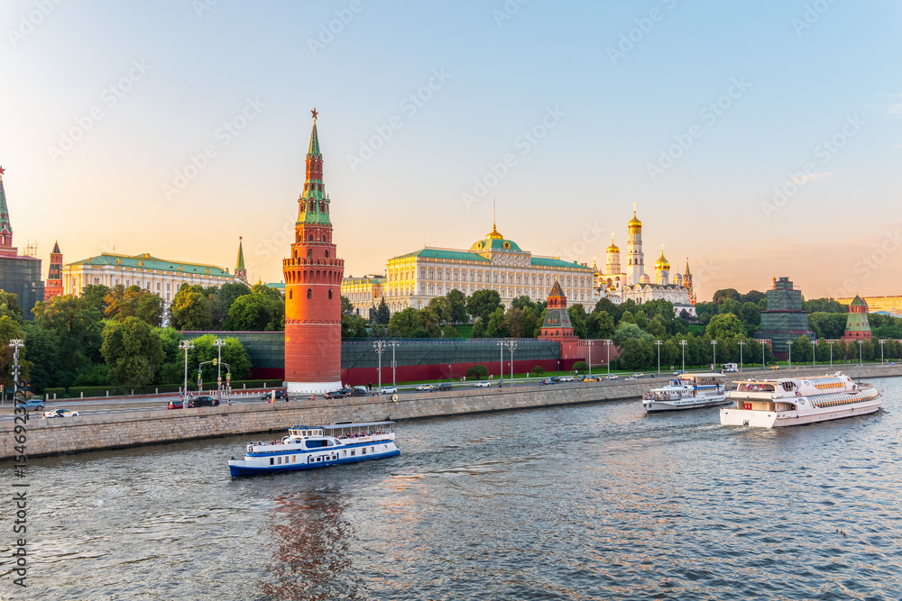 Obraz premium View of Kremlin with Vodovzvodnaya tower, Grand Kremlin Palace from repaired Bolshoy Kamenny Bridge in Moscow city on sunny summer day. Cruise ship sails on the Moscow river