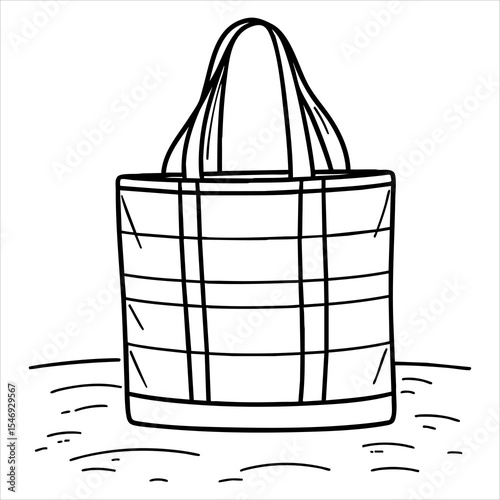 A tote bag with horizontal  vertical stripes sits on ground with sparse short grasslike markings