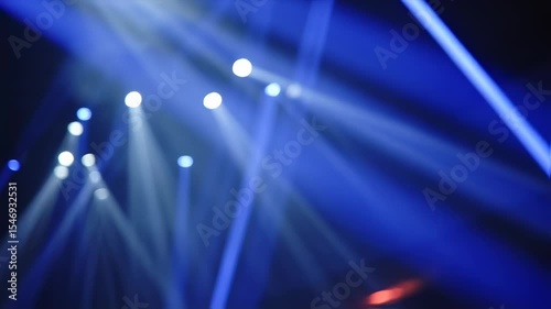 Dynamic stage lighting with blue beams creating an energetic atmosphere