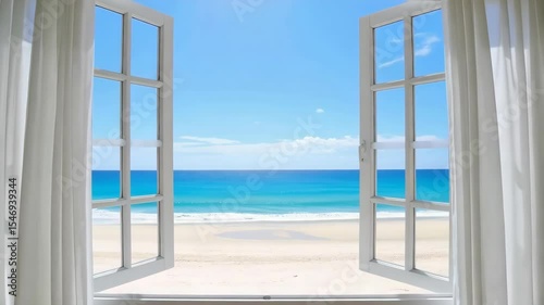 Open window view of turquoise ocean and sandy beach with white curtains blowing gently in the breeze on a sunny day