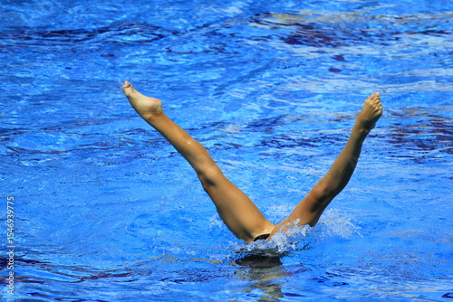 A swimmer's feet are above the surface of the water when half of his body and head are submerged.
