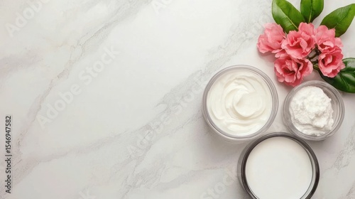 Flat lay arrangement of various ingredients and products for homemade or DIY moisturizer on a neutral marble or stone countertop background  Natural organic skincare concept with botanical elements