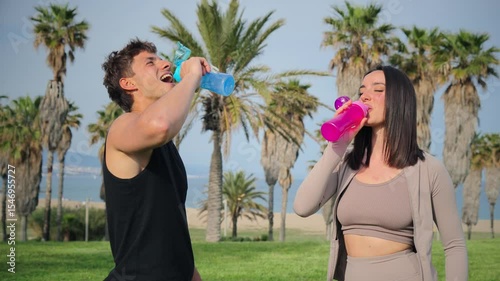 A happy couple enjoys a moment of celebration with colorful drinks, sharing laughter and joy in a delightful outdoor setting together, radiating energy and connection in every gesture.