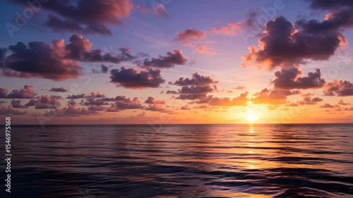 Vivid Sunset Over the Ocean With Pink and Purple Clouds Reflecting in Rippling Water Creating a Scenic Landscape