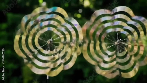 Garden Whirl: Metallic Wind Spinners in the Sun