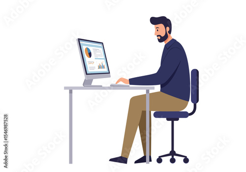 A man with a beard sits at a desk using a computer that displays graphs