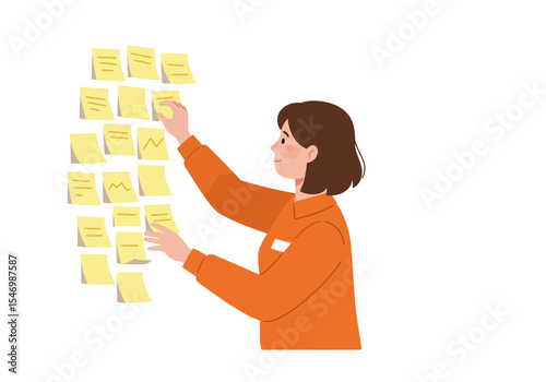 A woman in an orange shirt adds sticky notes to a wall side view