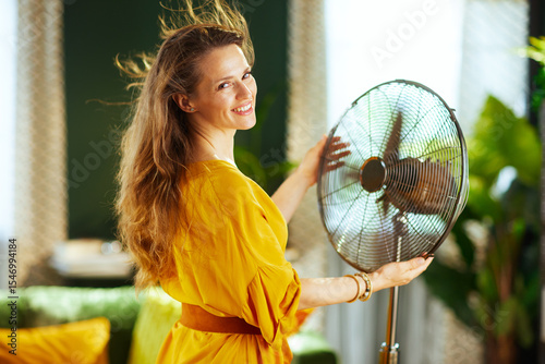 Cuadro en lienzo Smiling Woman Finds Cooling Relief with Fan