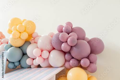 colorful balloon arch at baby girl's birthday party, room for copy