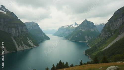 Overlooking Peaceful Lake Surrounded by Mountains and Green Landscape