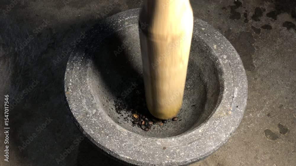 The traditional method of making ground coffee involves pounding roasted beans using a mortar and pestle to produce fine coffee powder with a strong aroma and rich flavor.