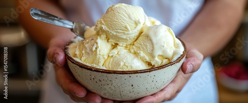 Hands holding a bowl full of creamy vanilla ice cream with a vintage spoon