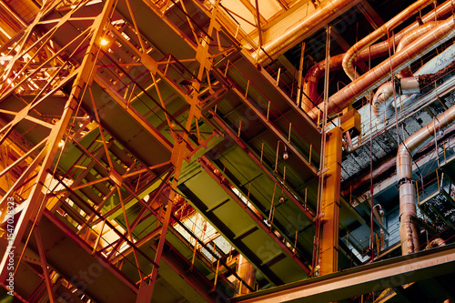 Industrial staircase structure with intricate metalwork and lighting in an urban setting at night