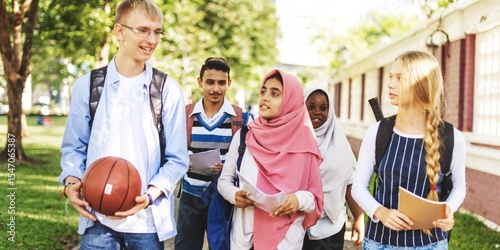 Fotografija Diverse group of students walking outdoors, holding books and a basketball