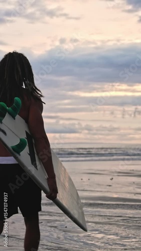 Man Surfer With Surf Board At Sea Nature And Ocean Water Waves On Background. Person At Coast Beach With Surfboard Going Away. Caucasian Guy At Seaside Bay Moves To Swimming or Surfing For Relaxation