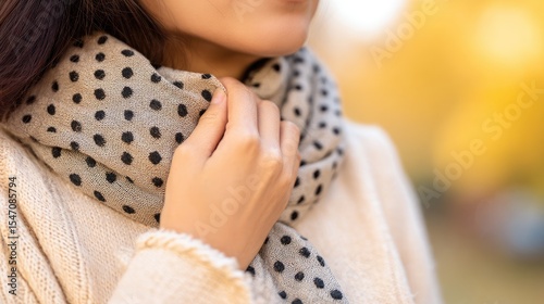 Person holding neck indiscomfort with looselywrapped warm scarf, concept ofwinter health issues, seasonalpain and self care for sore
muscles