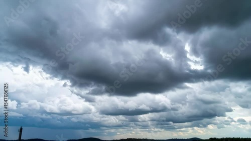 Dramatic sky filled with heavy, rolling storm clouds with a glimpse of sunlight breaking through, forecasting rain and approaching weather front